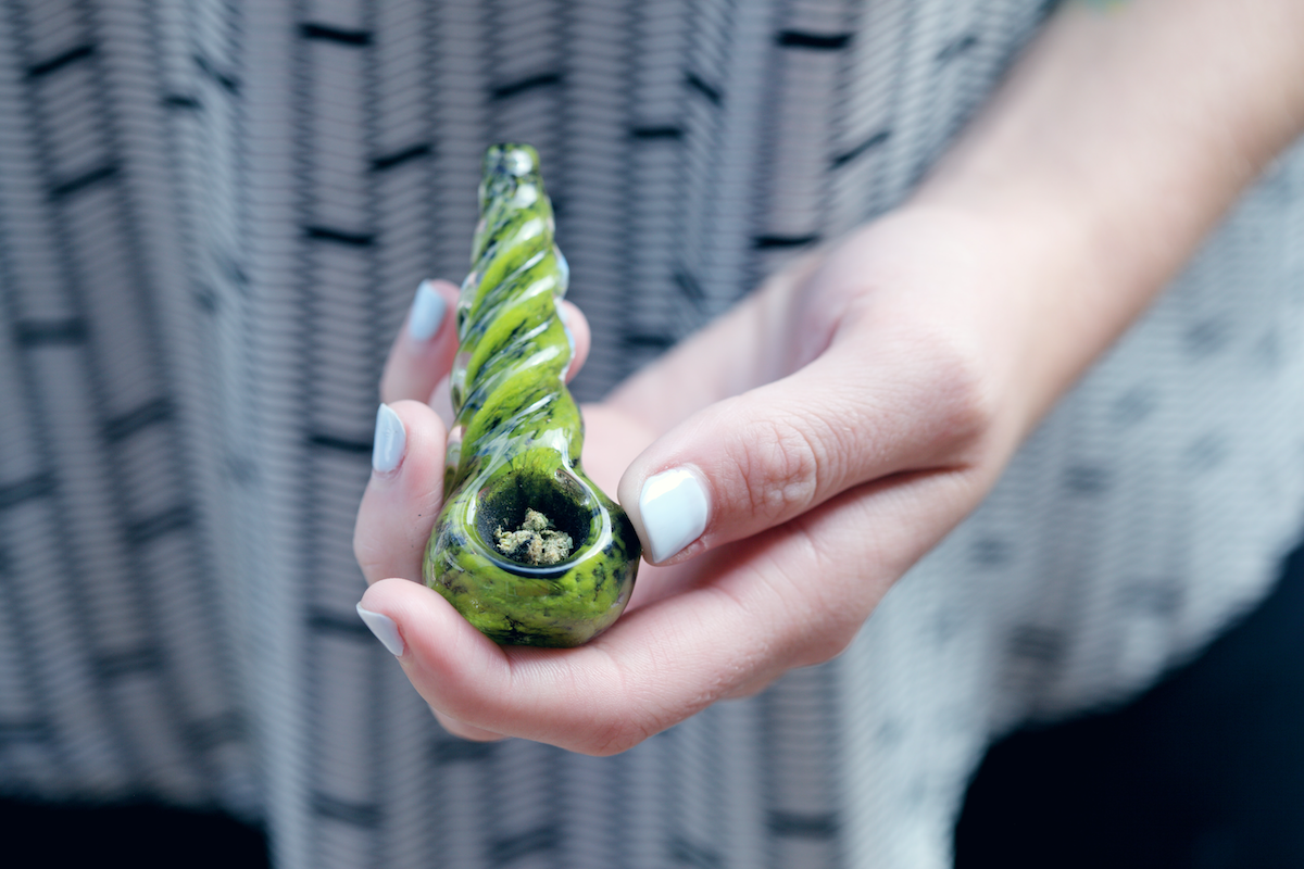 Holding a glass pipe with weed in the bowl