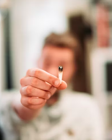 man holds up a tobacco-free joint